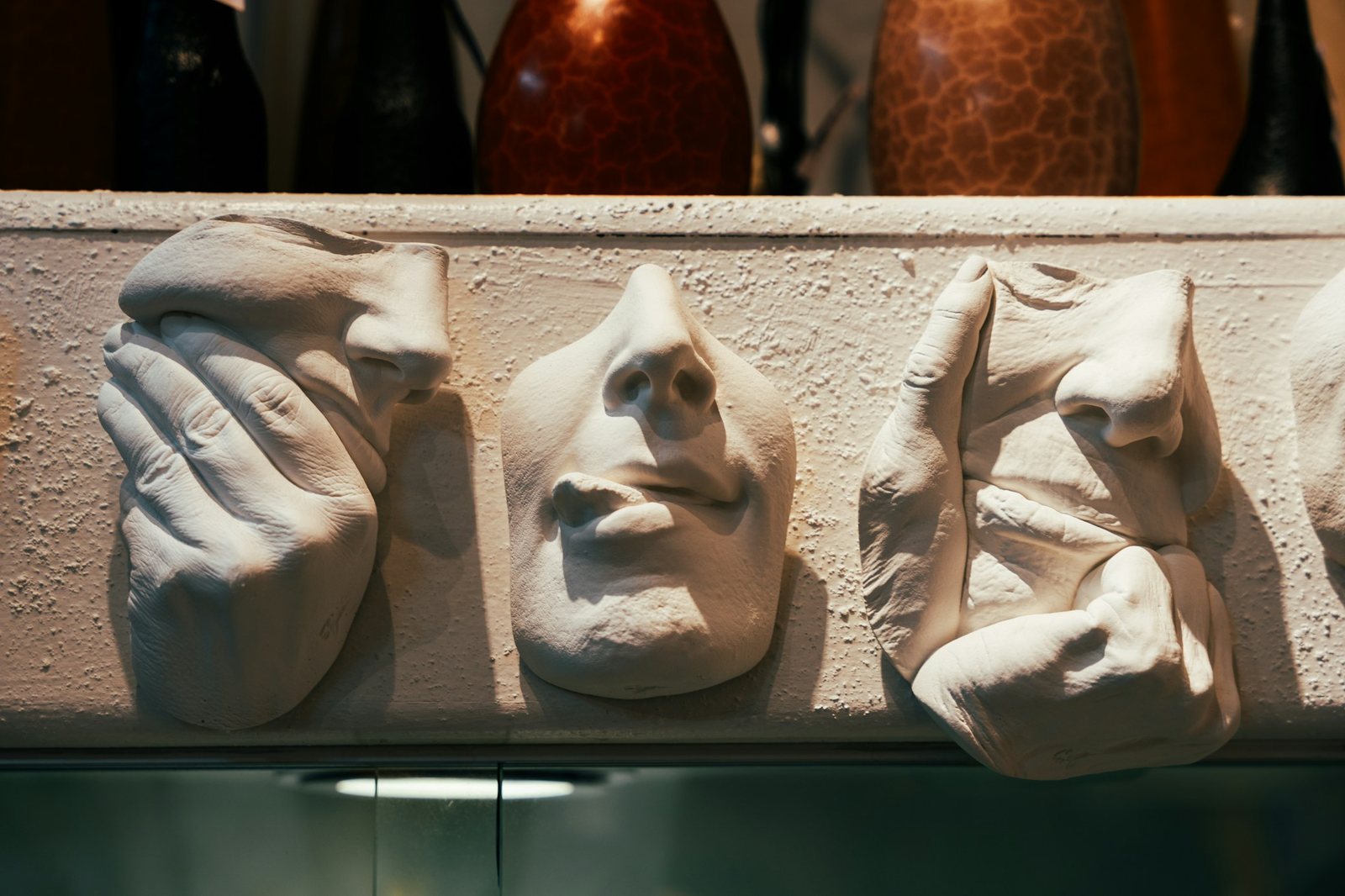 Row of cast plaster face reliefs