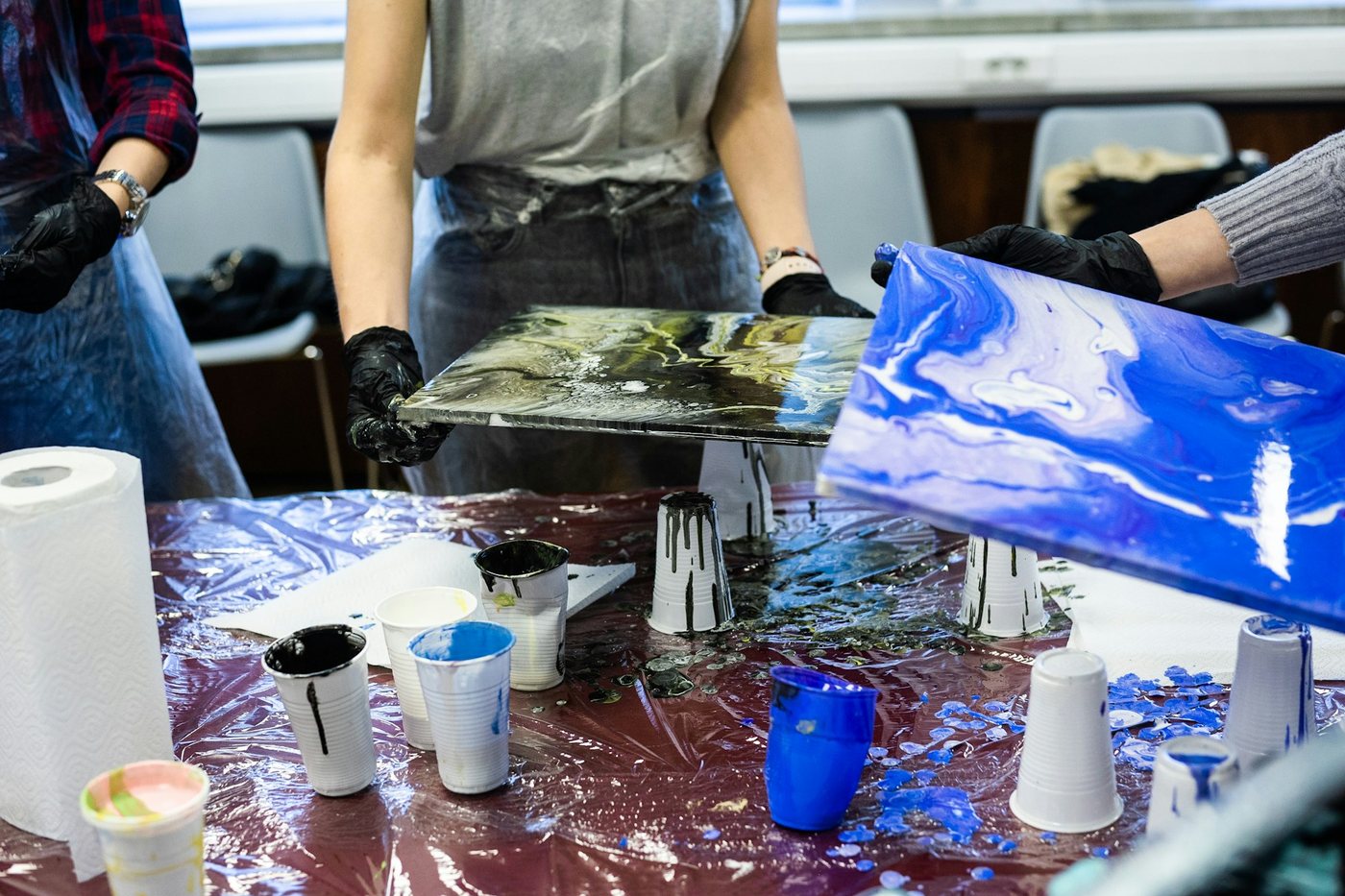 Resin being poured and mixed in a busy maker workshop