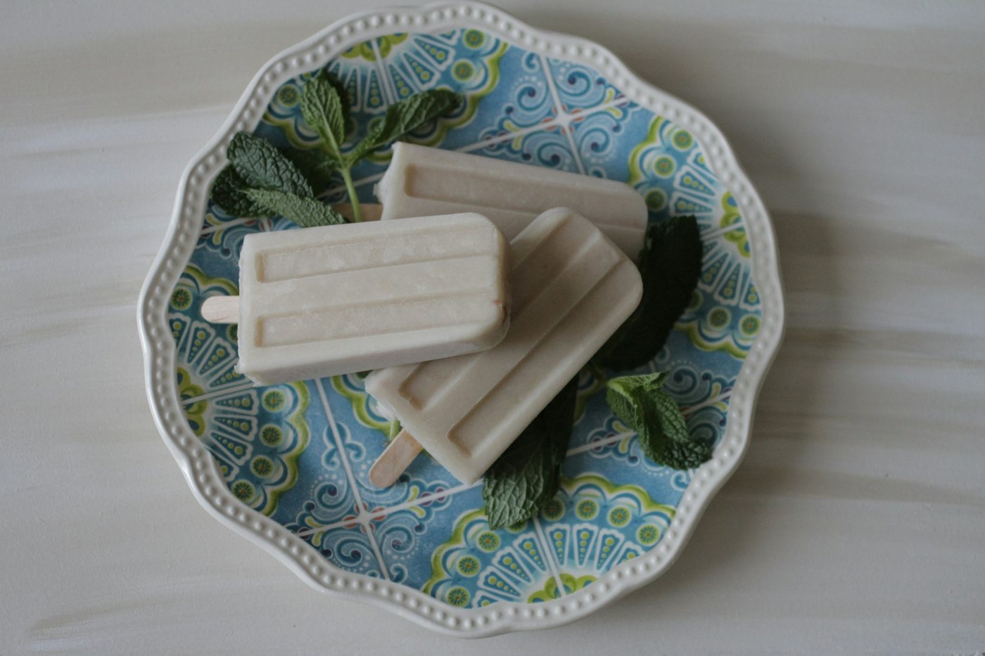 Ice lollies resting on a plate with fresh mint